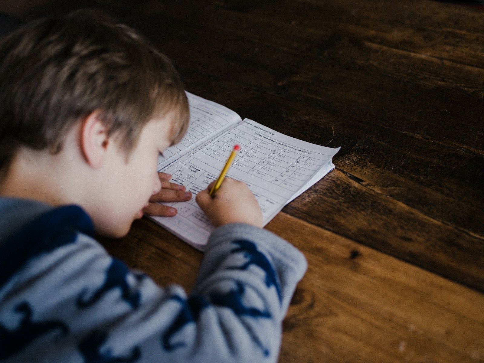A child working through a maths worksheet at a table